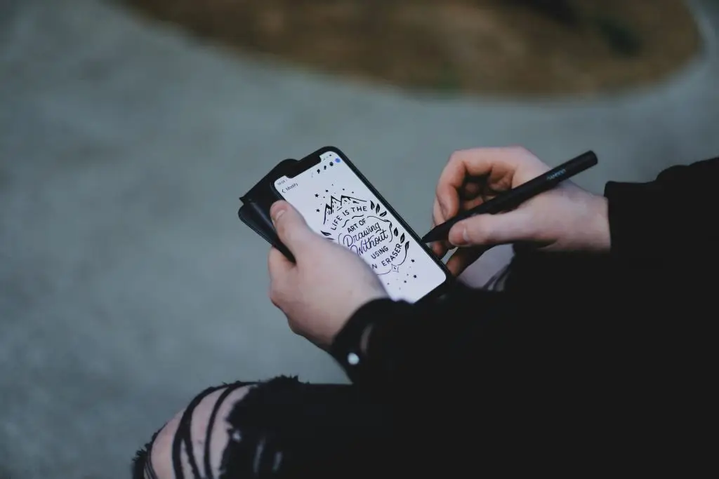 Person sketching a design on their phone