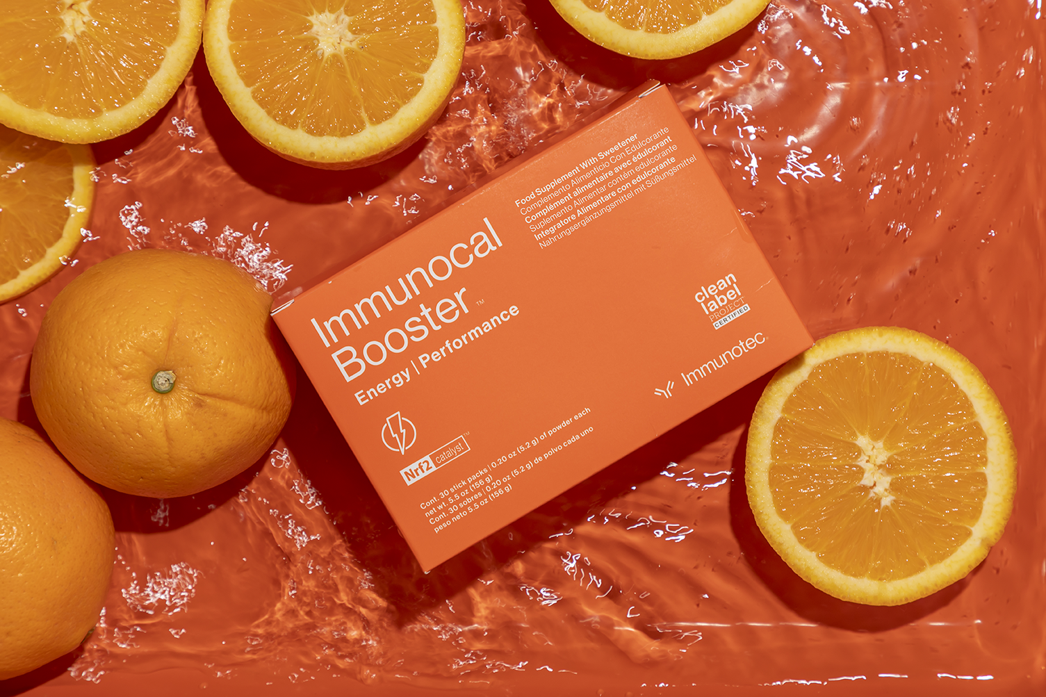 Immunocal Booster packaging on an orange backdrop with fruit - Flocksy