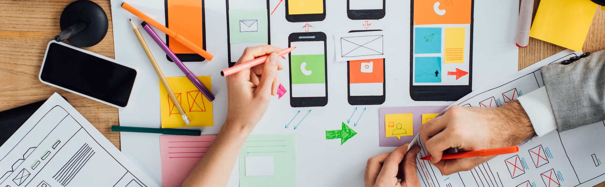 Stock image of hands arranging app screen mockups
