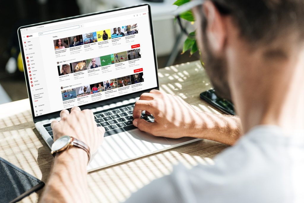man on youtube browsing videos video thumbnails on youtube