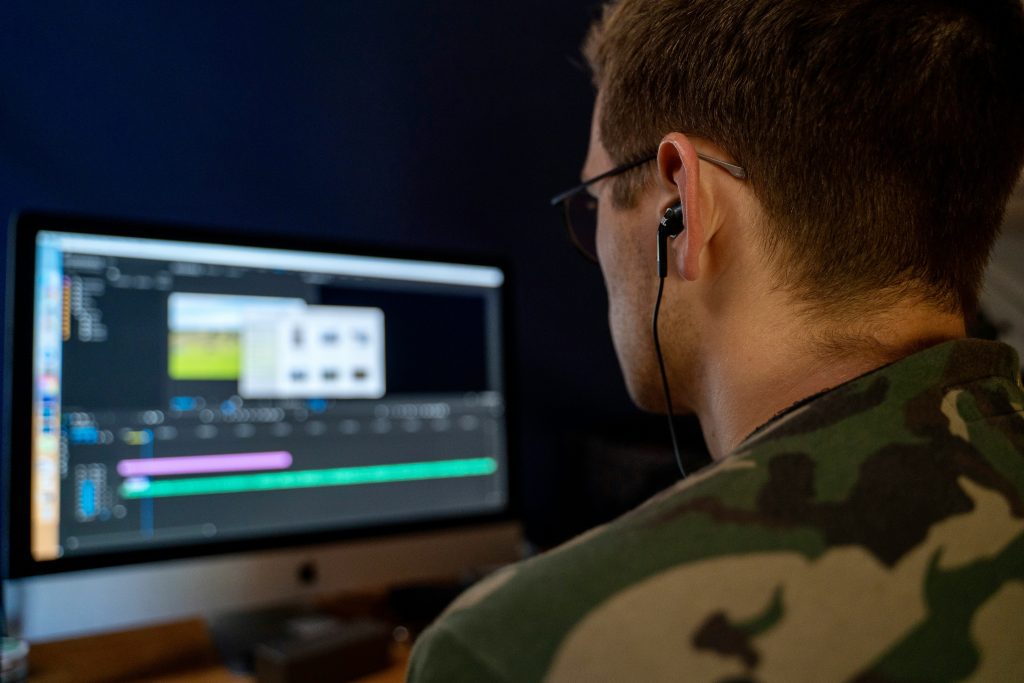 Person sitting at a computer editing a video
