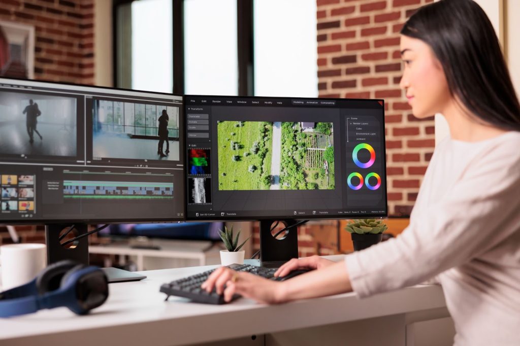 Woman sitting looking at two computer screens