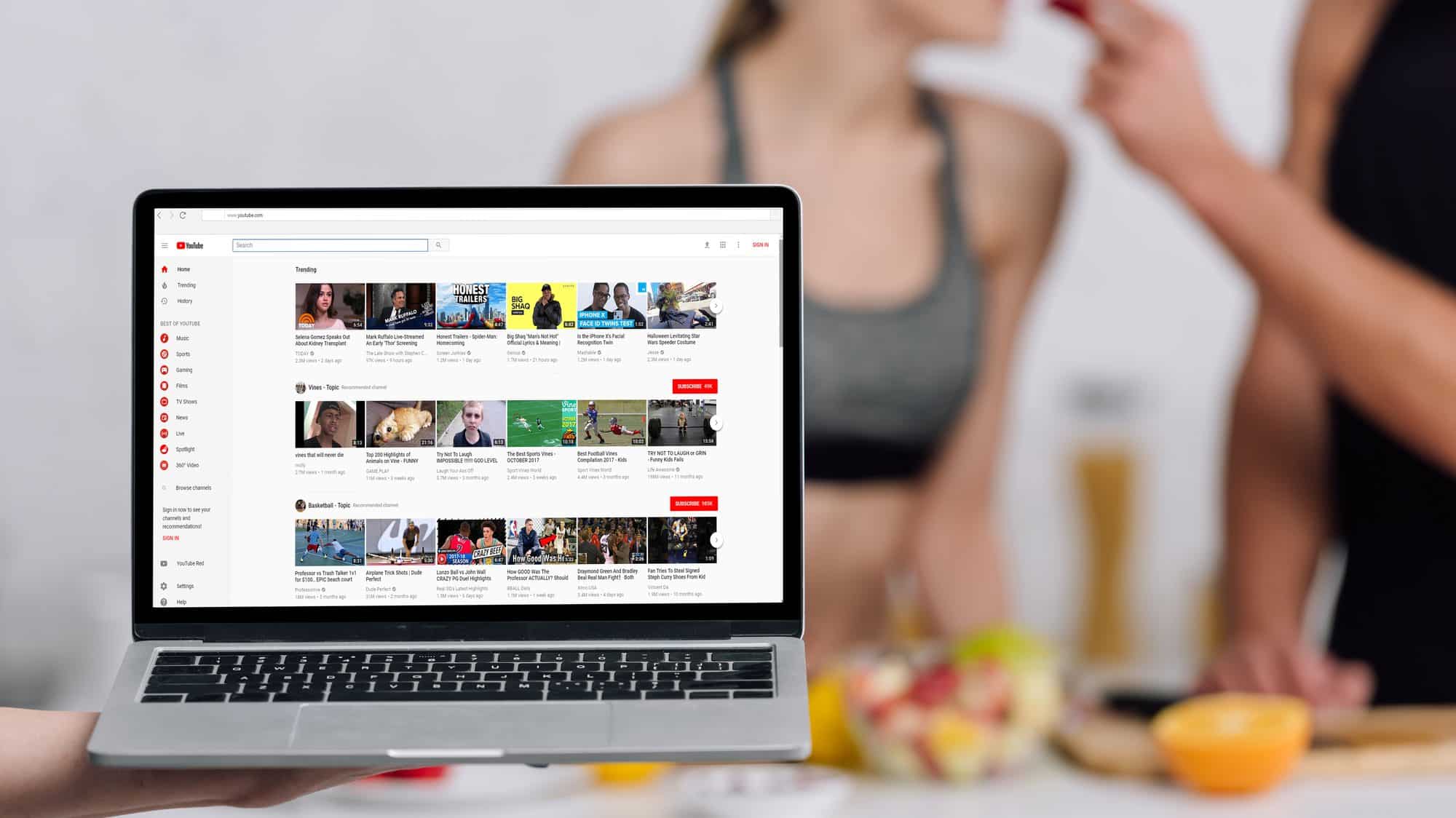 optimizing youtube content for various platforms holding laptop with youtube open food blog blurred in background