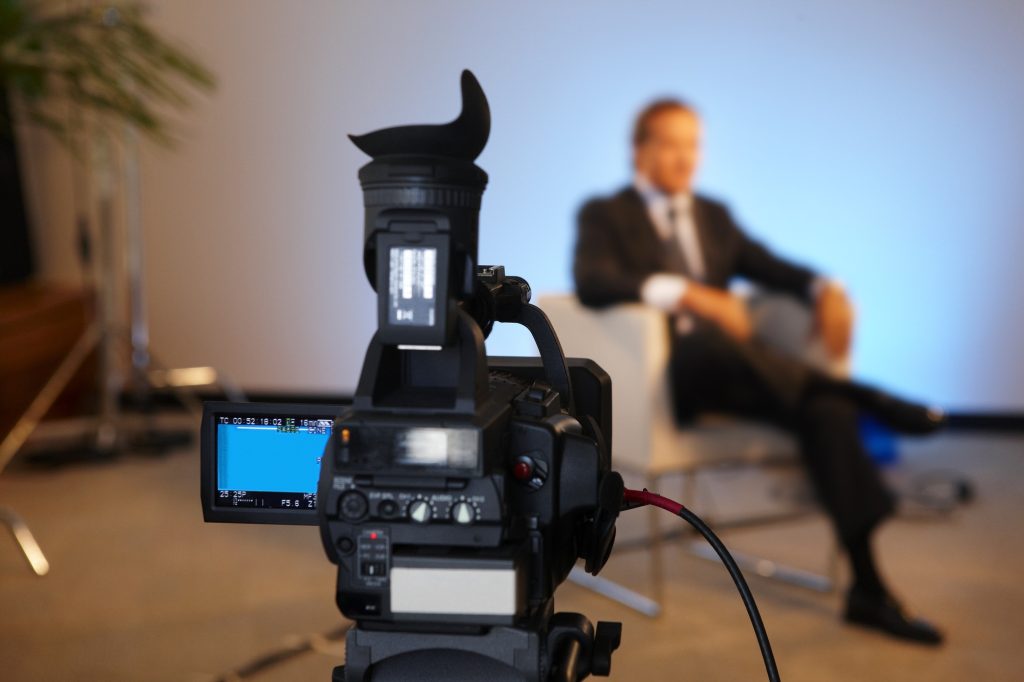 Television interview program with selective focus on camera screen copy space