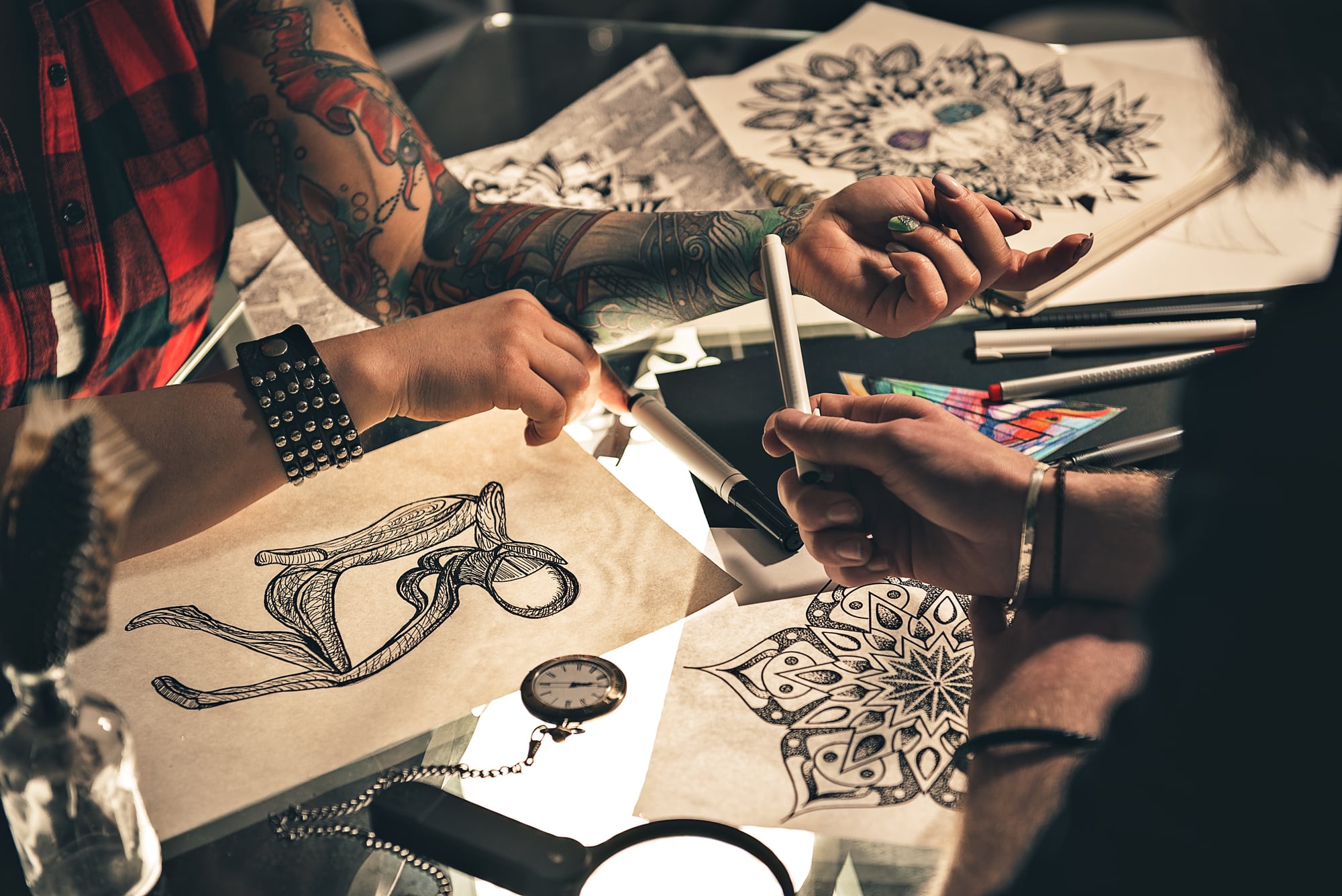 stock-photo-of-artists-client-discussing-tattoo-design