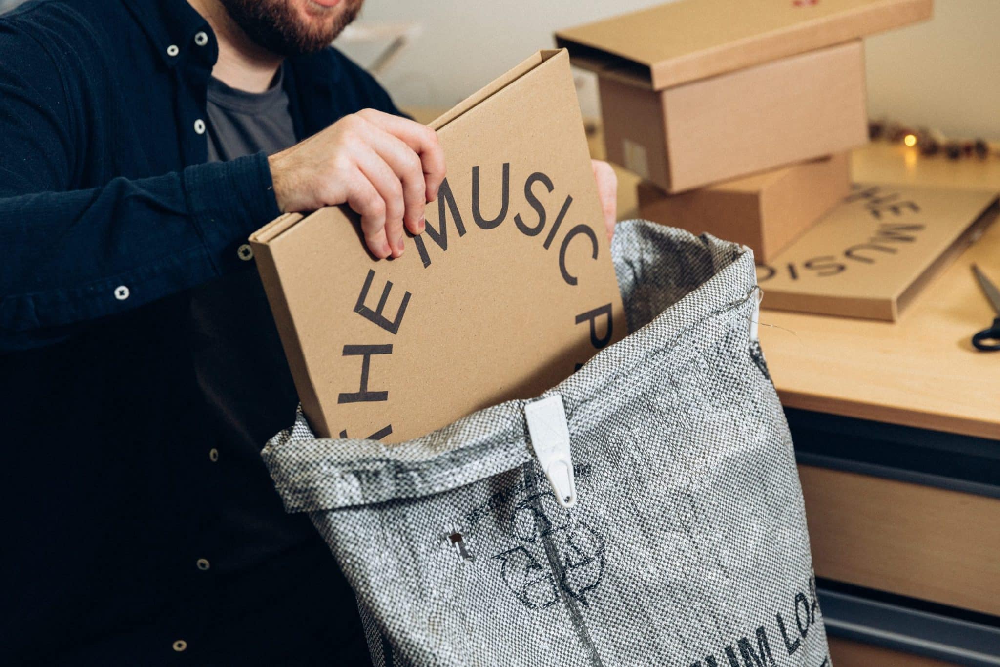 stock-photo-of-worker-packing-shipping-box-in-delivery-bag