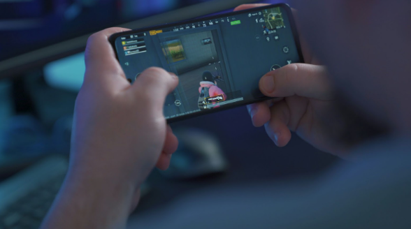 A person's hands shown playing a video game on their phone