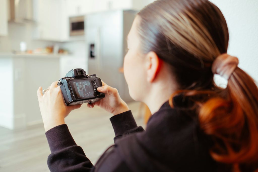 Woman looking into a camera and taking pictures